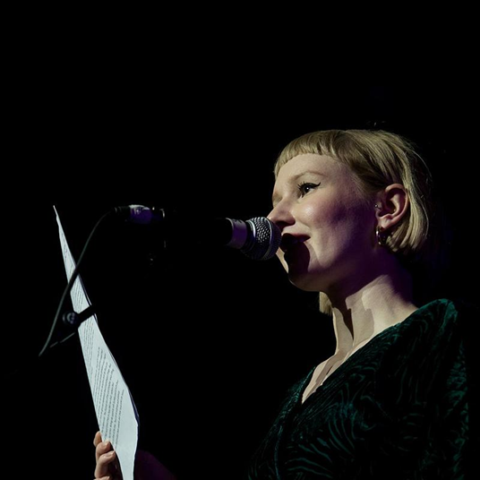 An author reading their work on stage